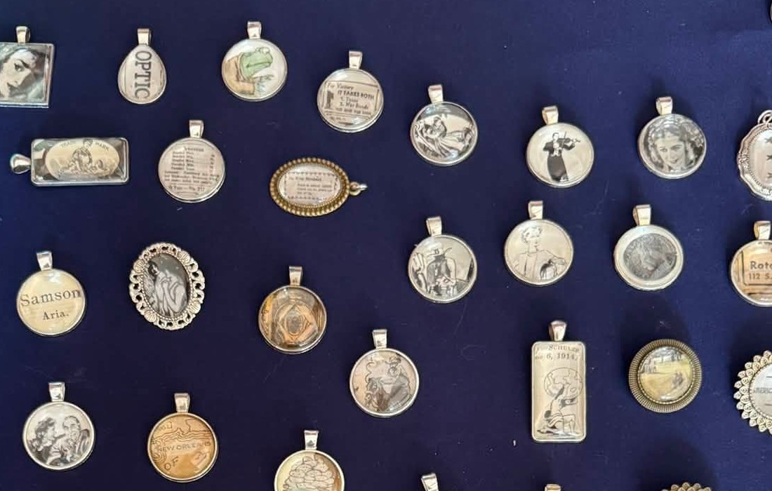 Close-up of pendants made from vintage newspaper and postcard fragments