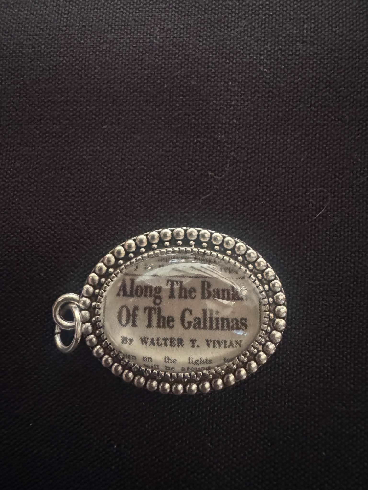 Pendant made from a vintage newspaper fragment reading 'Along the Banks of the Gallinas by Walter T. Vivian'