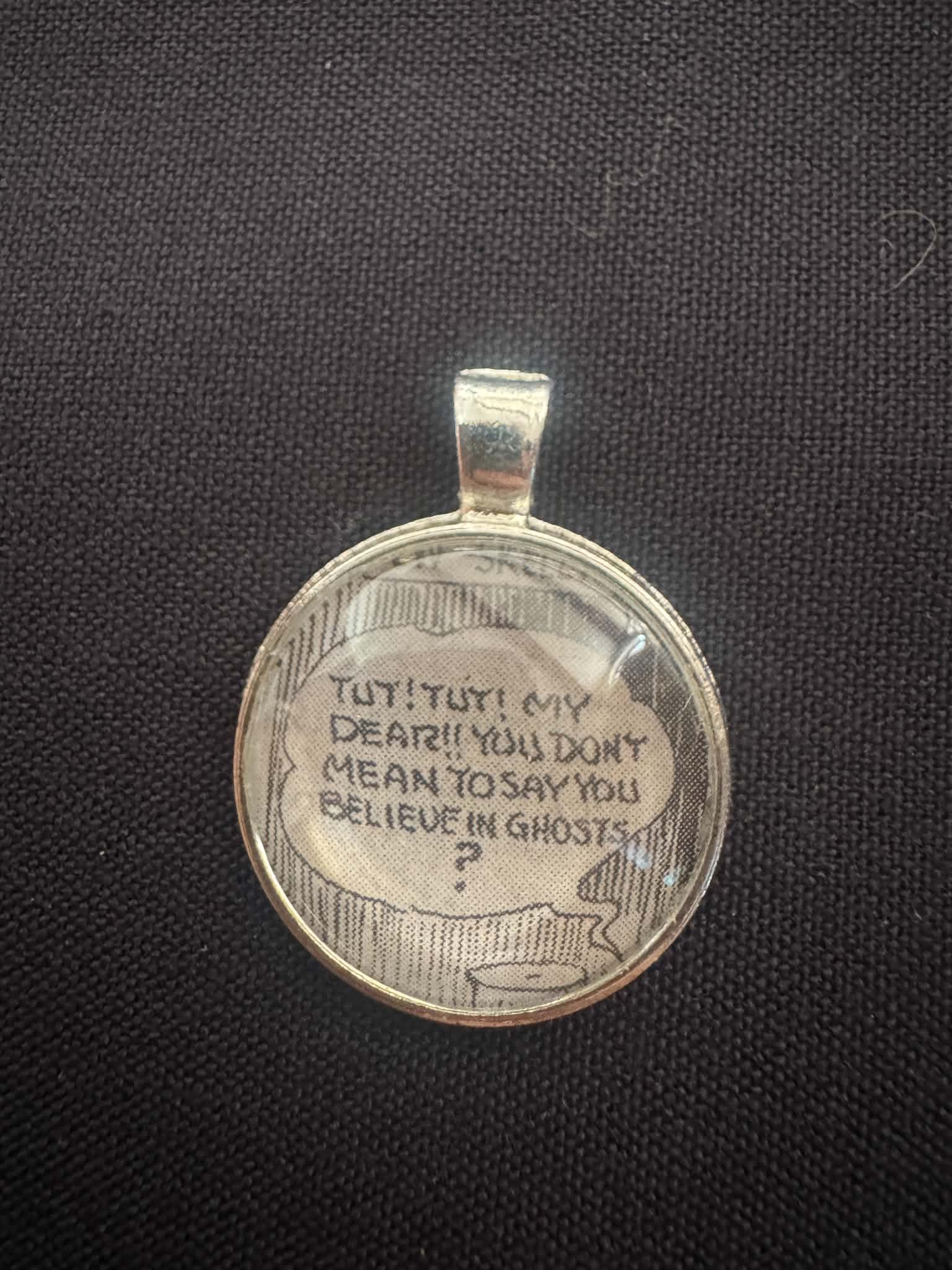Pendant made from a vintage comic fragment reading 'Tut! Tut! My dear!! You don't mean to say you believe in ghosts?'