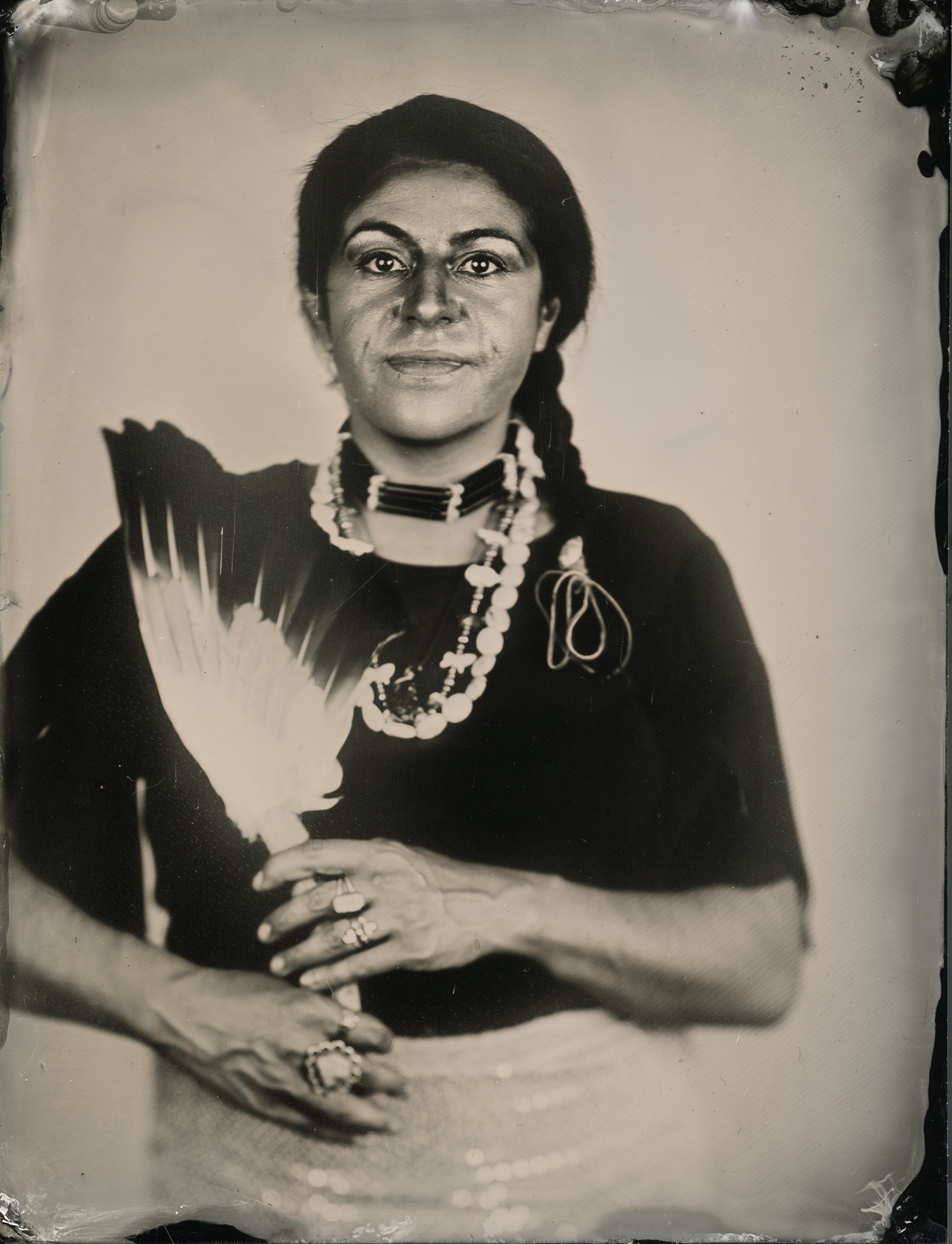 Wet plate portrait of Niña Terca holding a feather fan